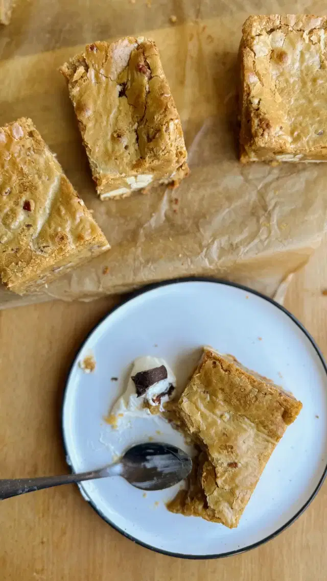 Chocoholic On The Loose - Episode 11

I developed a bit of a blondie obsession earlier this year after trying one from the shop at the @fiveacrefarmer . I’d always assumed I wasn’t a fan — they often felt too cakey or overly buttery to me. But it turns out, I just hadn’t tasted the real deal yet. I set myself the challenge of creating the perfect blondie recipe and here it is, all ready for you. 

Chai Spiced Pecan Blondies
Ingredients:
185g Unsalted Butter
200g White Chocolate
175g Light Brown Sugar
2 Eggs
¾ tsp Vanilla Extract
½ tsp Baking Powder
½ tsp Sea Salt
85g Plain Flour
30g Ground Almonds (approx. 1 heaped tsp)
40g Pecans, chopped
100g Chocolate Chips
Chai Spice Mix:
1 tsp Ground Ginger
1 tsp Ground Cinnamon
¼ tsp Ground Cloves
¼ tsp Ground Cardamom

Method:
- Preheat your oven to 170°C (fan). Grease and line an 8x8” or 9x9” baking tin.
- Brown the butter: Melt the butter in a saucepan over medium heat, letting it bubble and foam until it smells nutty and turns golden brown. Remove from the heat and set aside.
- Melt the white chocolate: While the butter is browning, gently melt the white chocolate in a heatproof bowl over a pan of simmering water or in short bursts in the microwave. Stir until smooth.
- Combine butter and chocolate: Once both are ready, stir the brown butter into the melted white chocolate until fully combined.
- Whisk eggs and sugar: In a separate bowl, whisk the eggs and light brown sugar until thick, pale, and mousse-like (this helps give a chewy, glossy top).
- Mix wet ingredients: Gently fold the vanilla and white chocolate–butter mixture into the egg mixture.
- Add dry ingredients: In another bowl, combine the flour, ground almonds, baking powder, salt, and the chai spice mix. Fold this into the wet mixture.
- Add the extras: Fold in the chopped pecans and chocolate chips.
- Bake: Pour the batter into your lined tin and smooth out the top. Bake at 170°C for about 20 minutes, until the top is lightly golden and set but still slightly soft in the middle.
-  Let cool in the tin before slicing into squares.

#blondie #pecanblondie #brownie #whitechocolate #chocolatechunks #chocolate